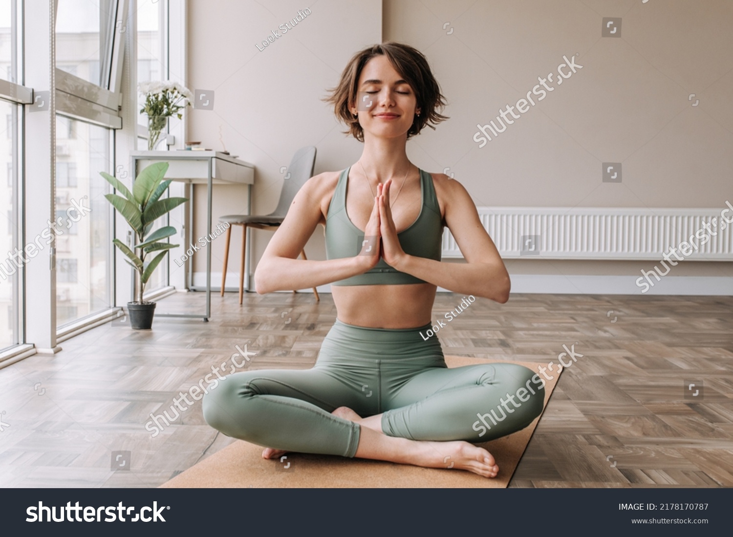 stock-photo-beautiful-cute-sporty-woman-doing-exercise-in-bright-room-focused-on-brunette-sitting-on-the-floor-2178170787